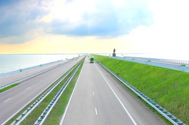 Highway on a great dam in Netherlands clipart