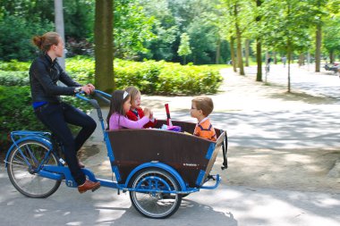 Young girl transporting children in the cart . Amsterdam. Nether clipart