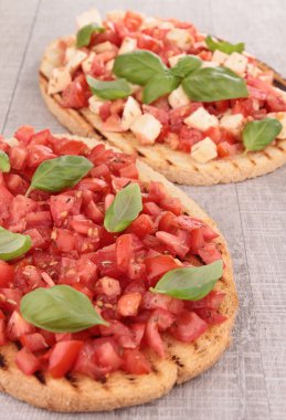 Domates, mozzarella ve fesleğenli bruschetta.