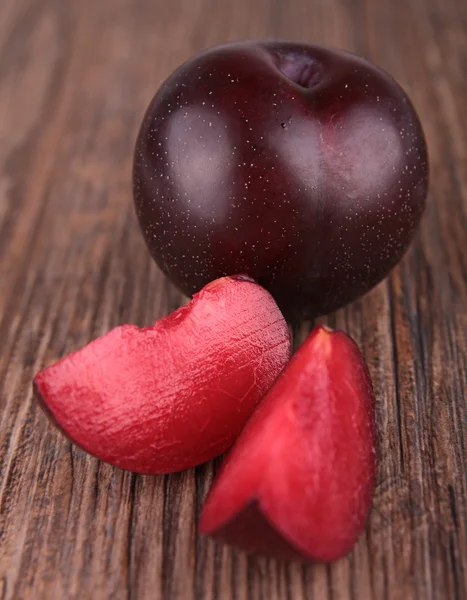 Rote Pflaumenfrüchte auf hölzernem Hintergrund — Stockfoto