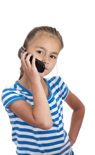 Lilla flickan talar av mobiltelefon, vit bakgrund — Stockfoto
