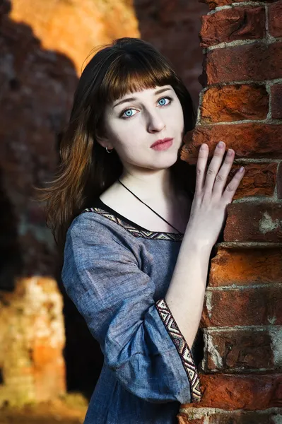Młoda piękna kobieta w pobliżu mur z cegły — Zdjęcie stockowe