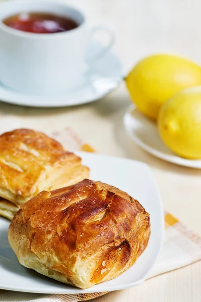 Bladerdeeg broodjes, citroenen en thee — Stockfoto