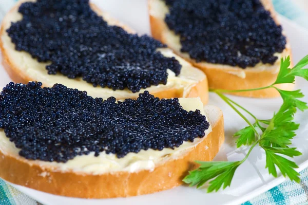 Caviar preto em uma fatia de pão e manteiga — Fotografia de Stock