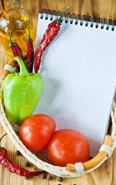 Notitieblok openen met groenten in de mand — Stockfoto