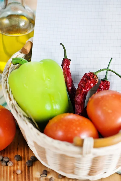 Notitieblok openen met groenten in de mand — Stockfoto