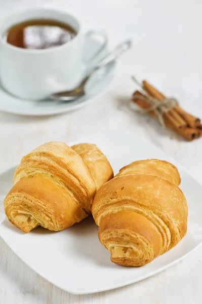 Croissants mit einer Tasse Tee — Stockfoto