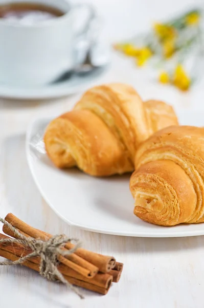 Croissant con tazza di tè e cannella — Foto Stock