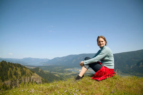 Kvinna sitter på toppen av en klippa — Stockfoto