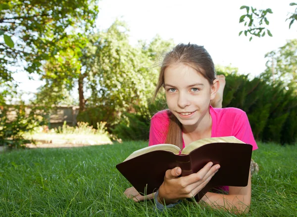 Teen girl reading the Bible outdoors — Stock Photo, Image