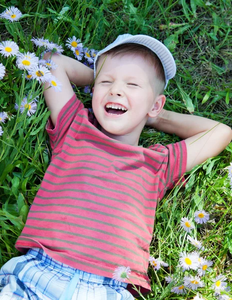 Malý chlapec leží na trávě — Stock fotografie