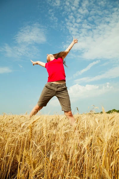 Teen girl jumping at a wheat field — Stock Photo, Image