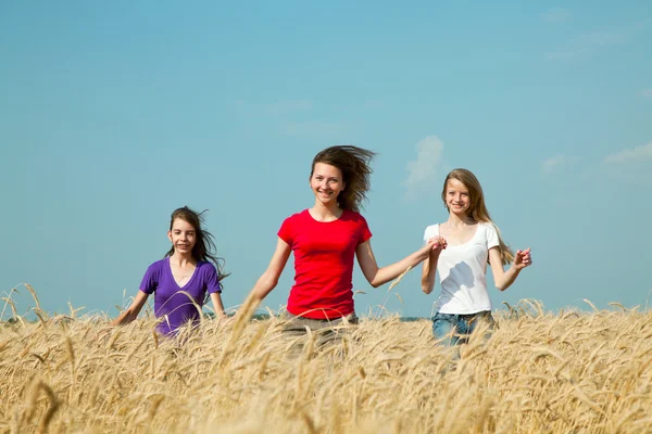 Teen girls running at the wheat field — Stock Photo, Image