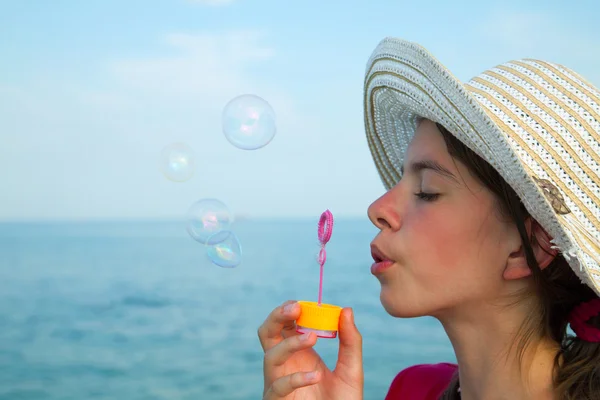 Giovanissima ragazza soffiando bolle — Foto Stock