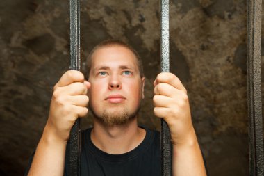 Young man behind the bars clipart