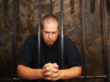 Young man behind the bars clipart