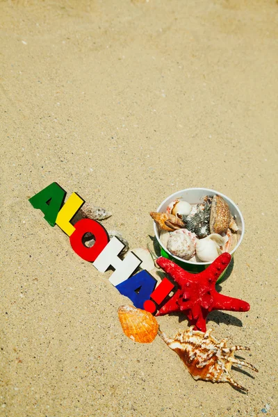 Palavra colorida de madeira 'Aloha' na areia — Fotografia de Stock
