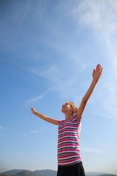 Teenage girl staying with raised hands — Stock Photo, Image