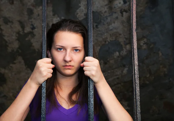 Junge Frau hinter Gittern — Stockfoto