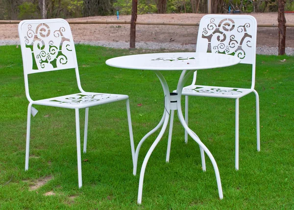 Белый стол и стулья на лужайке — стоковое фото