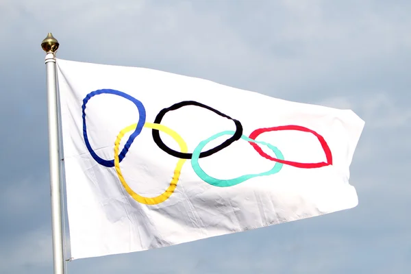 Олимпийский флаг, размахивающий в небе — стоковое фото