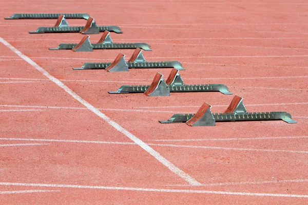 Atletika startovací bloky na červené běžecká dráha — Stock fotografie