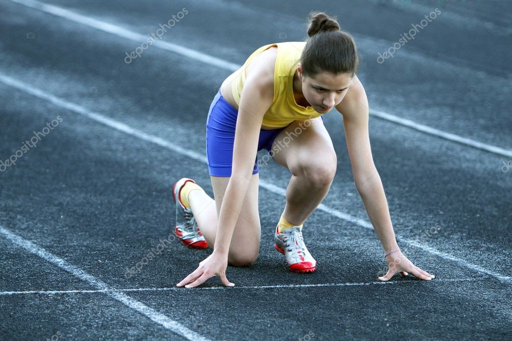 Athletic teenage girl in start position on track . Stock Photo by  ©DenysKuvaiev 11218985