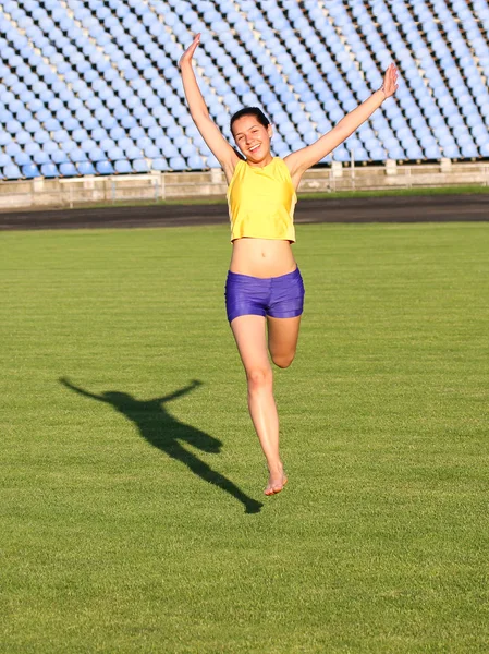 Schönes Teenager-Sportmädchen läuft auf dem Rasen. — Stockfoto