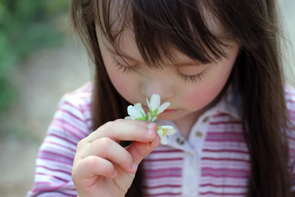 Retrato de menina bonita com flores no parque — Fotografia de Stock