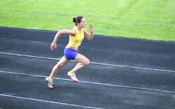 Chica corriendo en la pista — Foto de Stock