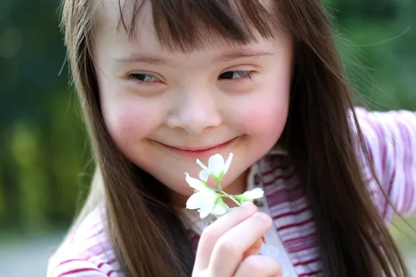 Retrato de una hermosa joven con flores en el parque — Foto de Stock