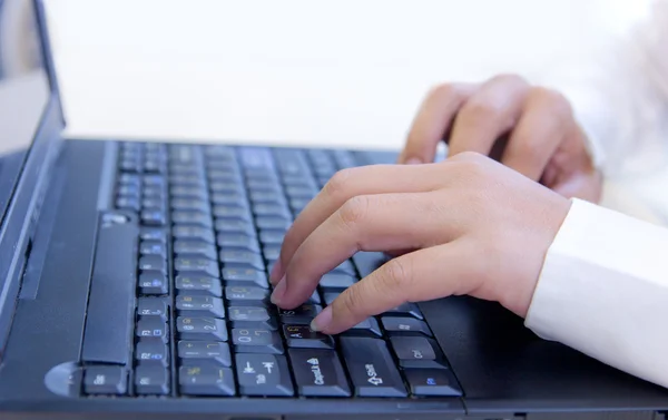 Frau tippt mit der Hand auf Notebook-Tastatur — Stockfoto