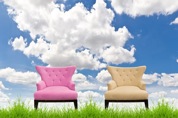 Pink and cream sofa on green grass against blue sky — Stock Photo, Image