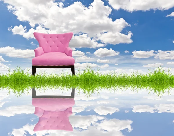 Růžový gauč na zelené trávě a modrá obloha — Stock fotografie