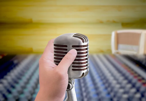 Hand holding microphone in sound record room — Stock Photo, Image