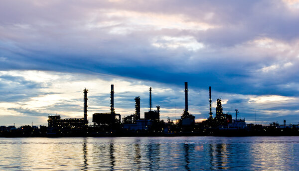 Silhouette Oil refinery plant at morning along river in Bangkok