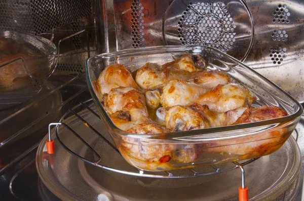 Chicken legs on a glass dish in the convection oven — Stock Photo, Image
