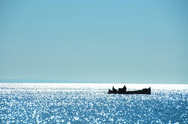 Uitzicht op de zee en de vissers in de boot — Stockfoto