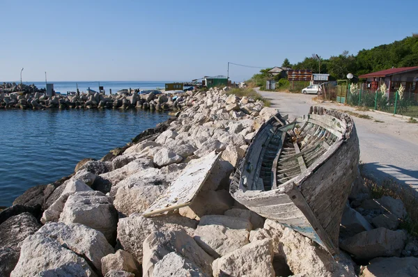 Gamla båt på stenar nära Svarta havet — Stockfoto
