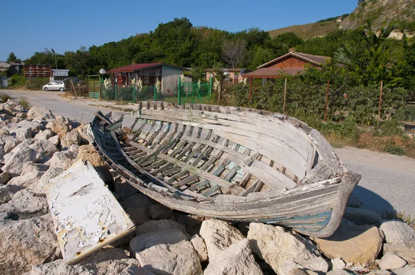 Velho barco nas pedras perto do mar negro — Fotografia de Stock