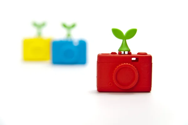 Zoom in red silicon compact camera with green leaf on top — Stock Photo, Image