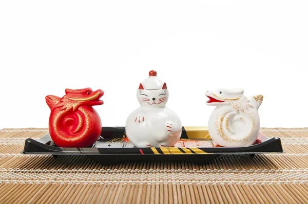 Ceramic cat and dragon on plastic tray isolated on white background — Stock Photo, Image