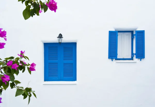 Два голубых окна на белой стене здания — стоковое фото