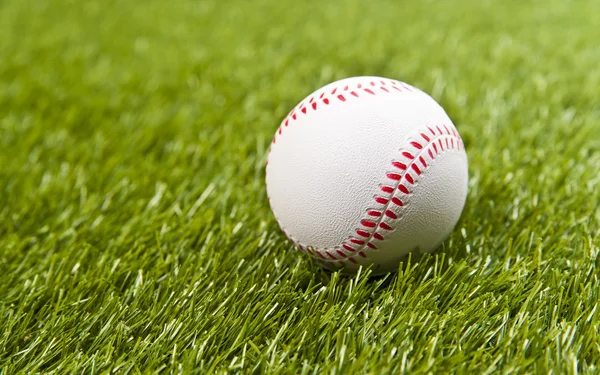 Beyzbol sahte yeşil çimenlerin üzerinde — Stok fotoğraf