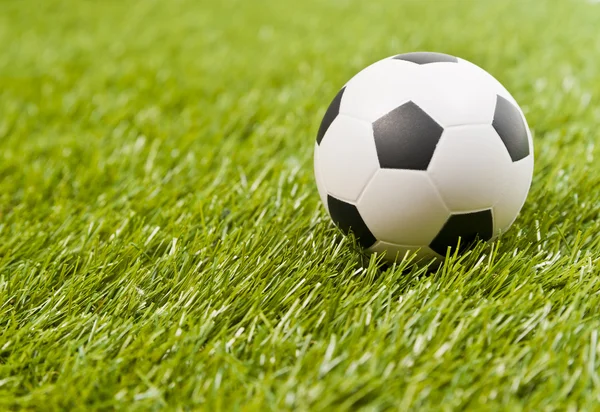 Футбол на фальшивой зеленой траве — стоковое фото