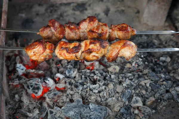 Cucini lo spiedino fatto di pezzi di carne e verdura shish su spiedo sotto carbone caldo Fotografia Stock