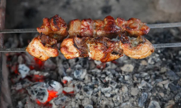 Cook shish kebab on skewer under hot coal Stock Photo