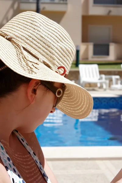 Havuz tarafında oturan genç kadın — Stok fotoğraf