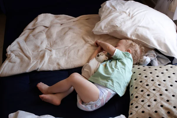 Ett barn som sover på golvet — Stockfoto