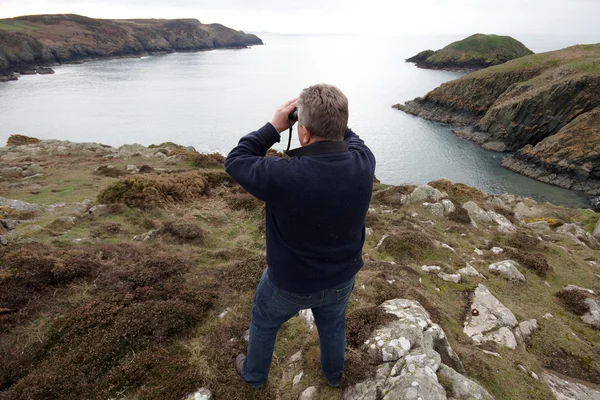 A mature man looking through binoculars — Stock Photo, Image